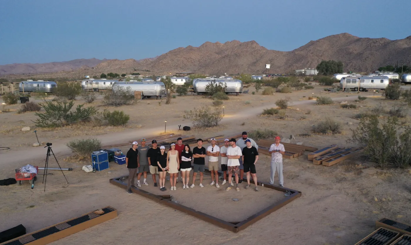 The Outer Spaces team standing together at a desert build site